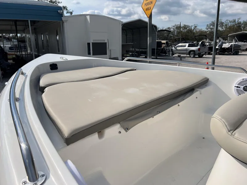 Slide: The Image of 2025 Key West 1720 Center Console boat with beige seating, parked outdoors. - 11