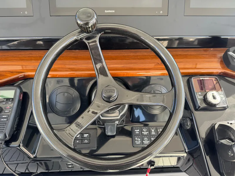 Slide: The Image of Steering wheel of 2022 Everglades 395cc boat with control panel and wood accents. - 10