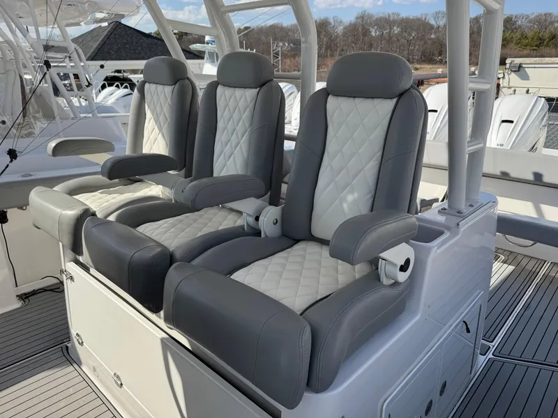 Slide: The Image of Luxurious seating on 2022 Everglades 395cc boat, featuring quilted upholstery and armrests. - 14