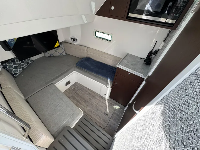 Slide: The Image of 2022 Everglades 395cc cabin interior with seating, TV, and compact kitchenette. - 19