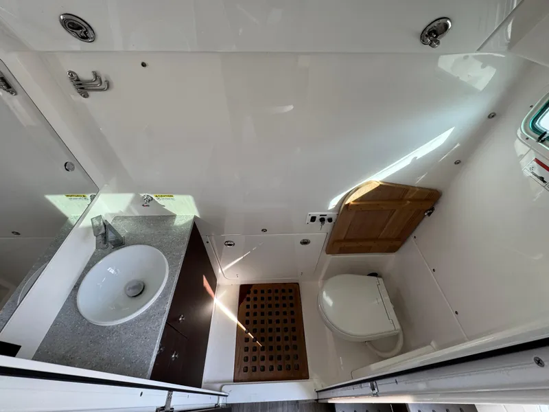 Slide: The Image of Modern boat bathroom with sink, toilet, and wooden floor mat in 2022 Everglades 395cc. - 21