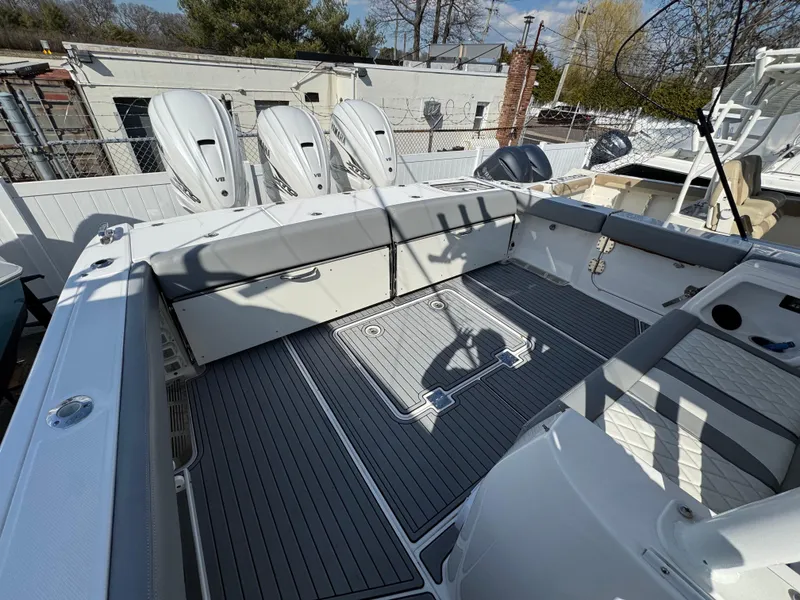 Slide: The Image of 2022 Everglades 395cc boat deck with triple outboard engines, featuring spacious seating and modern design. - 22