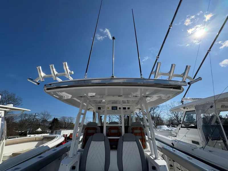 Slide: The Image of 2022 Everglades 395cc boat with fishing rod holders under clear blue sky. - 7