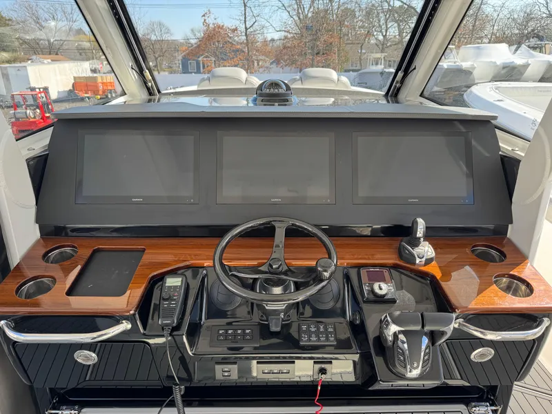 Slide: The Image of Control panel of 2022 Everglades 395cc boat with three screens and steering wheel. - 9