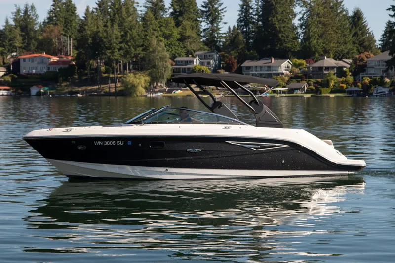 Slide: The Image of 2020 Sea Ray SLX 250 boat on a serene lake with forested shoreline. - 14