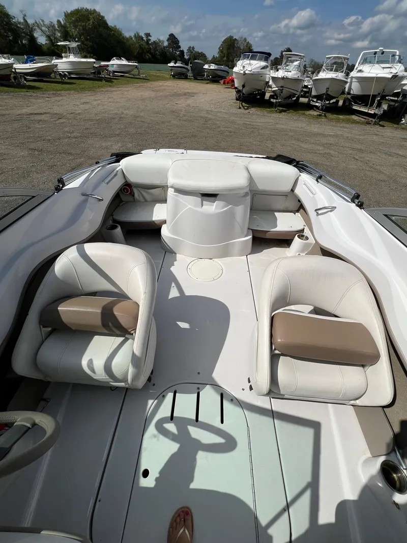 Slide: The Image of 2008 Four Winns H180 boat interior with white seating, parked among other boats. - 11