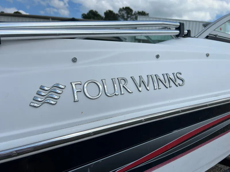 Slide: The Image of 2008 Four Winns H180 boat with logo and chrome details under a cloudy sky. - 12