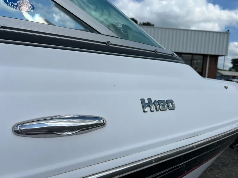 Slide: The Image of 2008 Four Winns H180 boat side view with logo and chrome detail. - 13