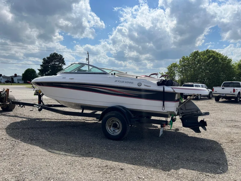 Slide: The Image of 2008 Four Winns H180 boat on trailer under cloudy sky. - 2