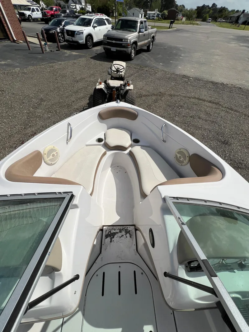 Slide: The Image of 2008 Four Winns H180 boat interior with seating and windshield, parked on gravel. - 9