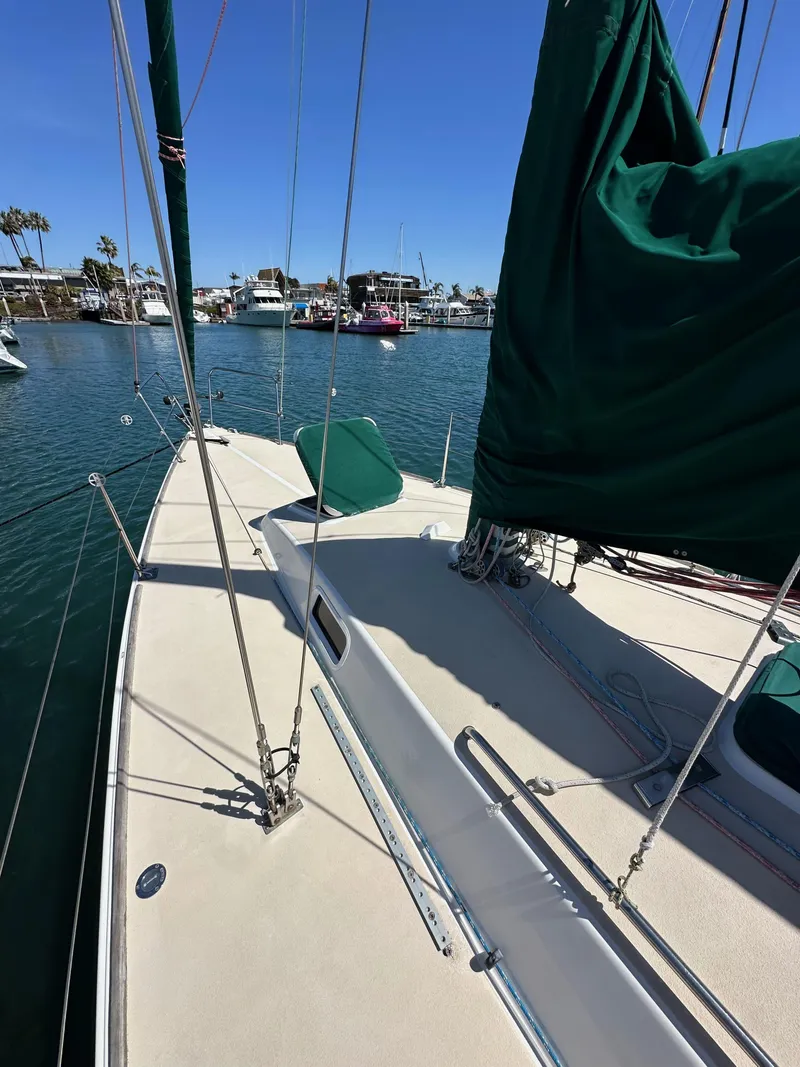 Slide: The Image of 1996 J Boats J/120 sailboat deck with green sail cover, docked in marina. - 12
