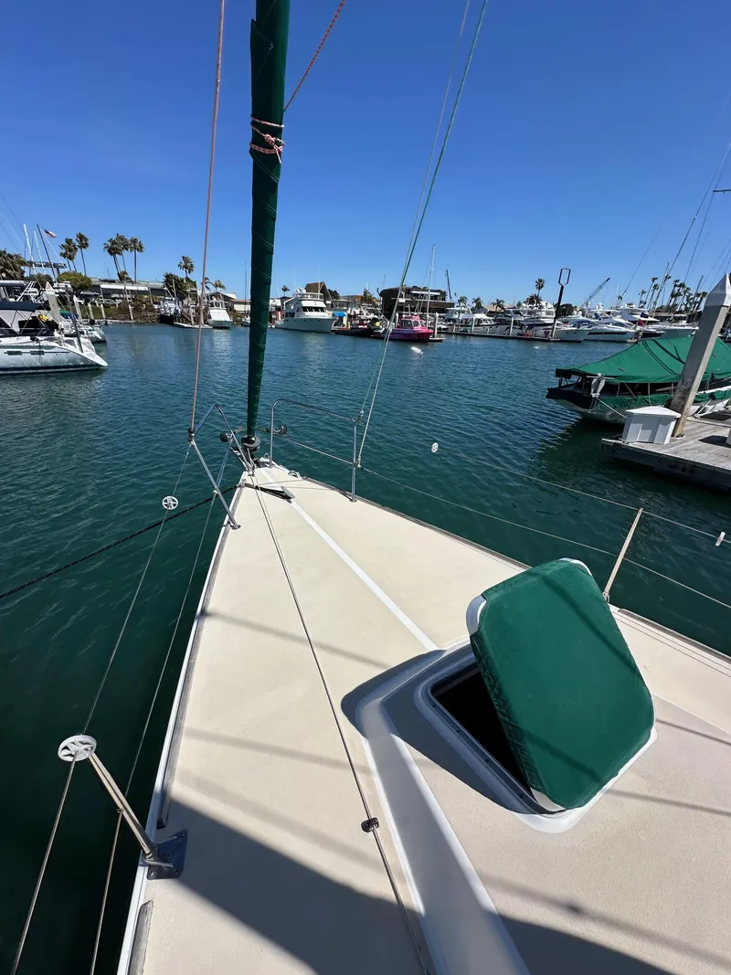 Slide: The Image of 1996 J Boats J/120 sailboat deck view in a marina with clear blue sky. - 14