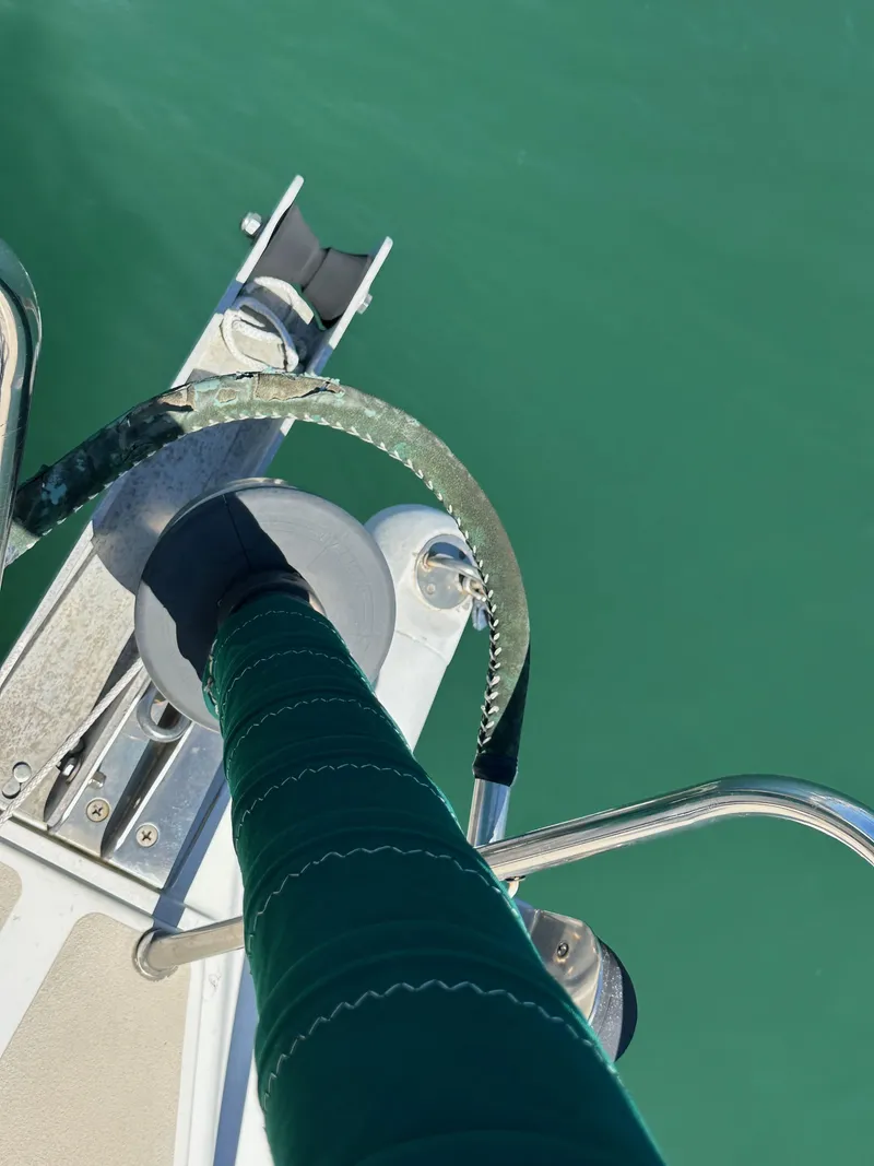 Slide: The Image of Close-up of a 1996 J Boats J/120 sailboat deck with green water background. - 16