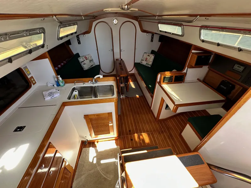 Slide: The Image of Interior of a 1996 J Boats J/120 sailboat, featuring a cozy cabin with wood finishes. - 36