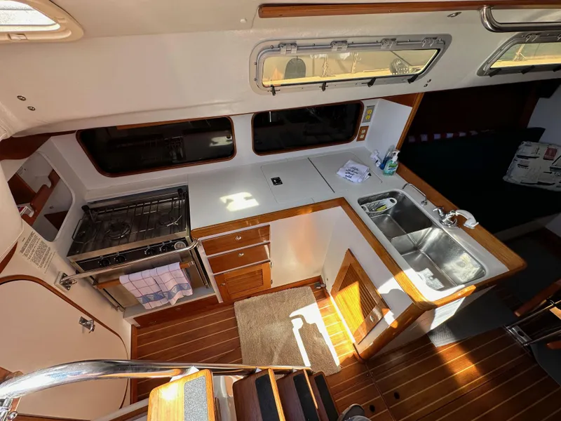 Slide: The Image of Interior of 1996 J Boats J/120 yacht, featuring a compact kitchen with stove and sink. - 37
