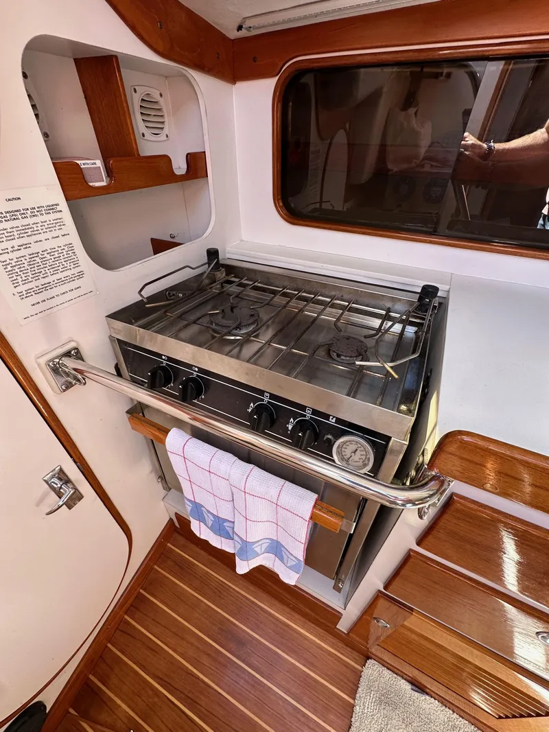 Slide: The Image of 1996 J Boats J/120 yacht kitchen with stove, wooden flooring, and towel rail. - 39