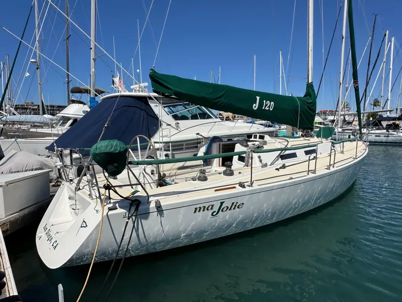 Slide: The Image of Sailboat J/120 from 1996 docked in marina, featuring green sail cover. - 4