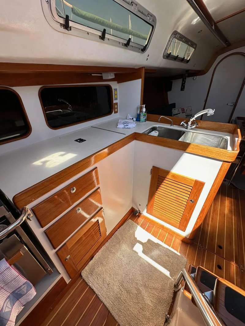Slide: The Image of 1996 J Boats J/120 interior with wooden cabinetry and compact kitchen area. - 40