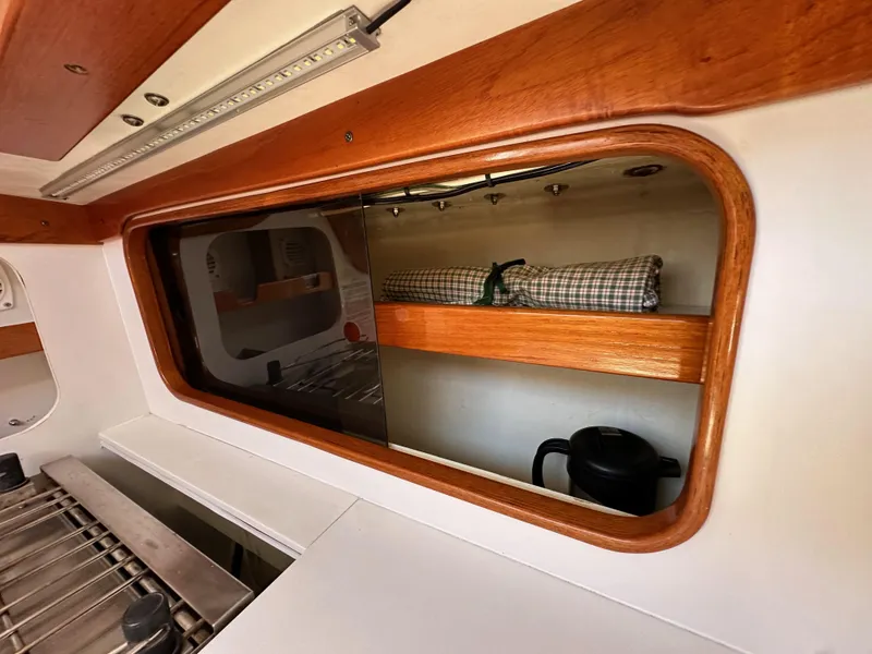 Slide: The Image of Interior of 1996 J Boats J/120, featuring wooden shelves and a window view. - 43