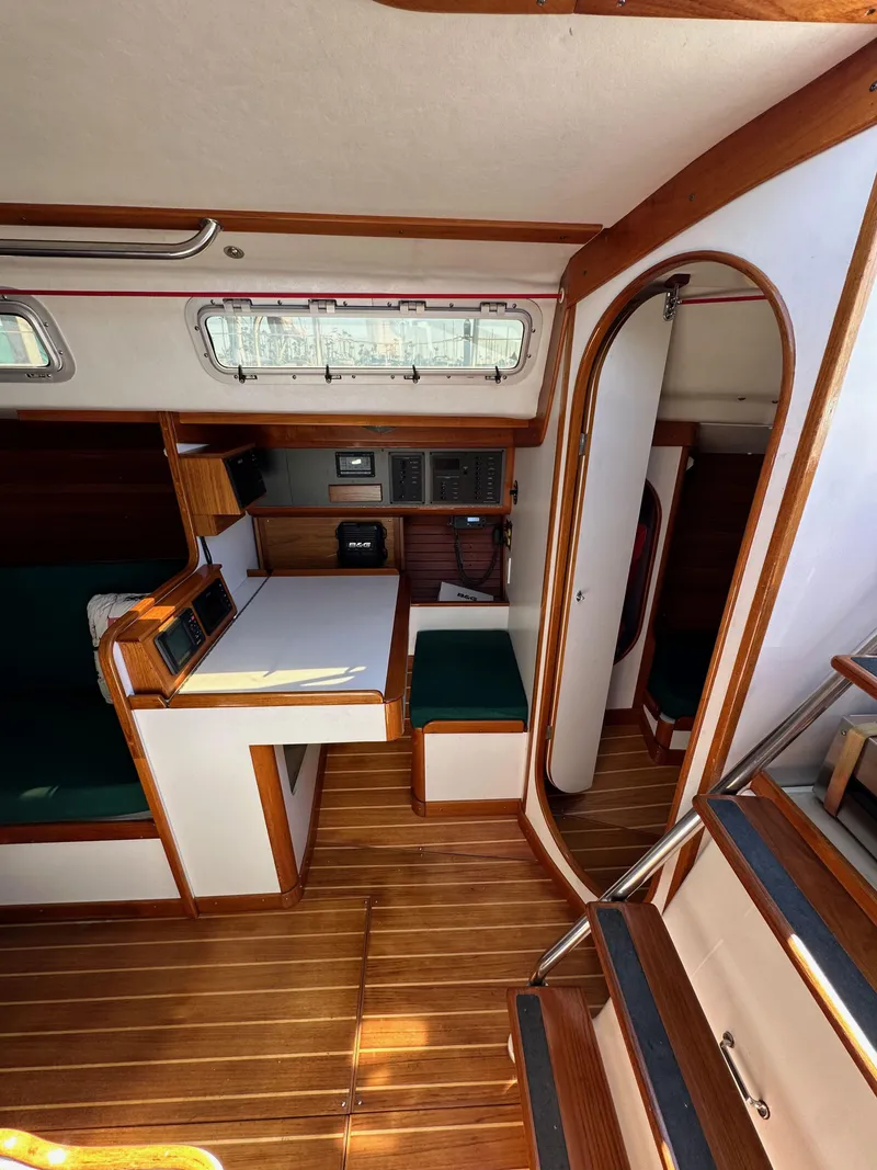 Slide: The Image of Interior of 1996 J Boats J/120 sailboat with wood finish and compact dining area. - 44