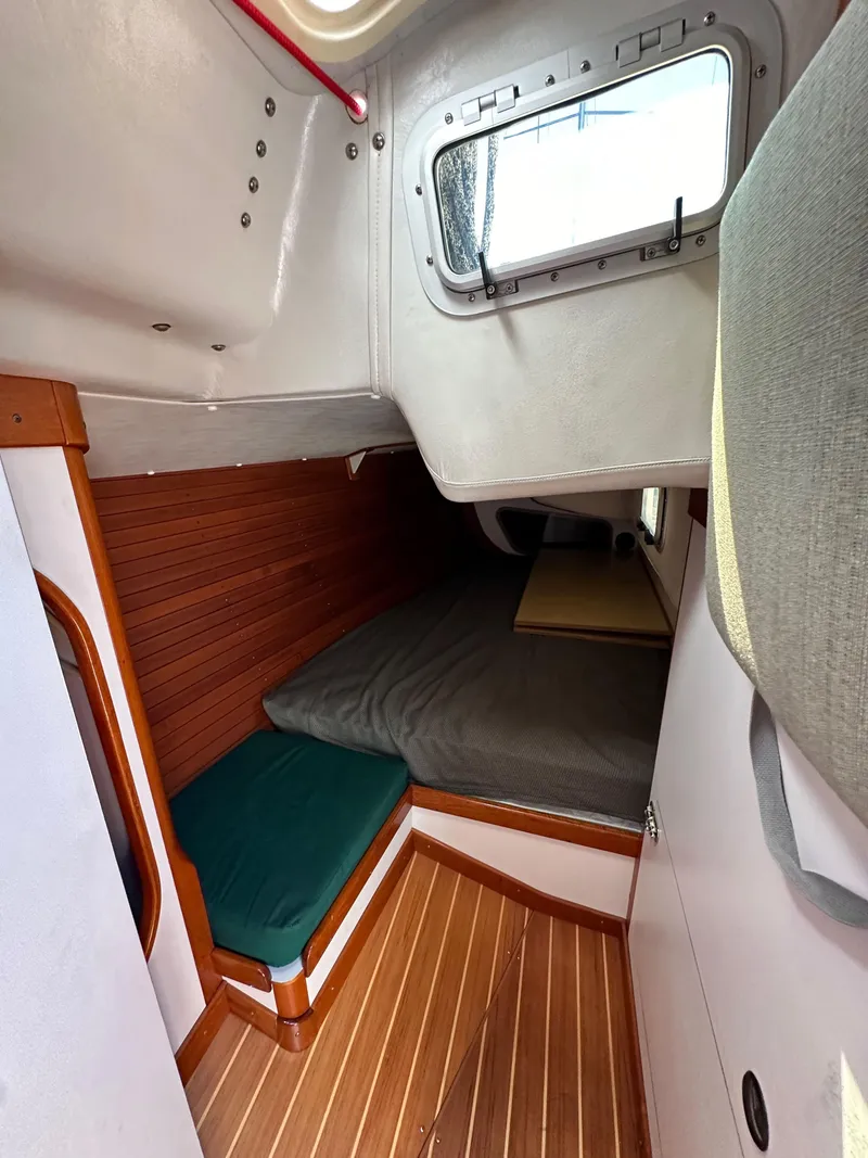 Slide: The Image of 1996 J Boats J/120 cabin interior with wooden flooring and cozy sleeping area. - 46