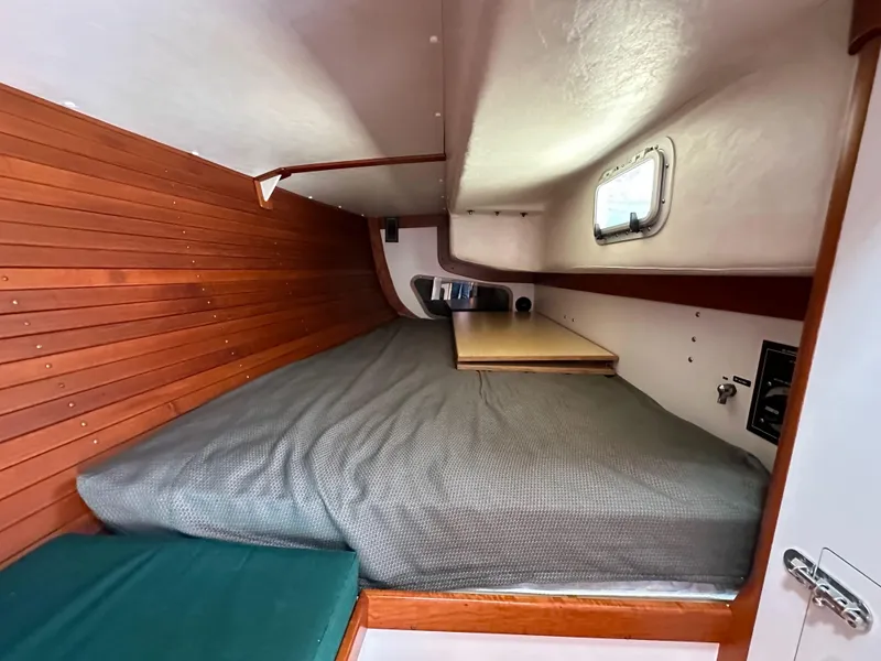 Slide: The Image of 1996 J Boats J/120 cabin interior with wooden paneling and cozy sleeping area. - 47
