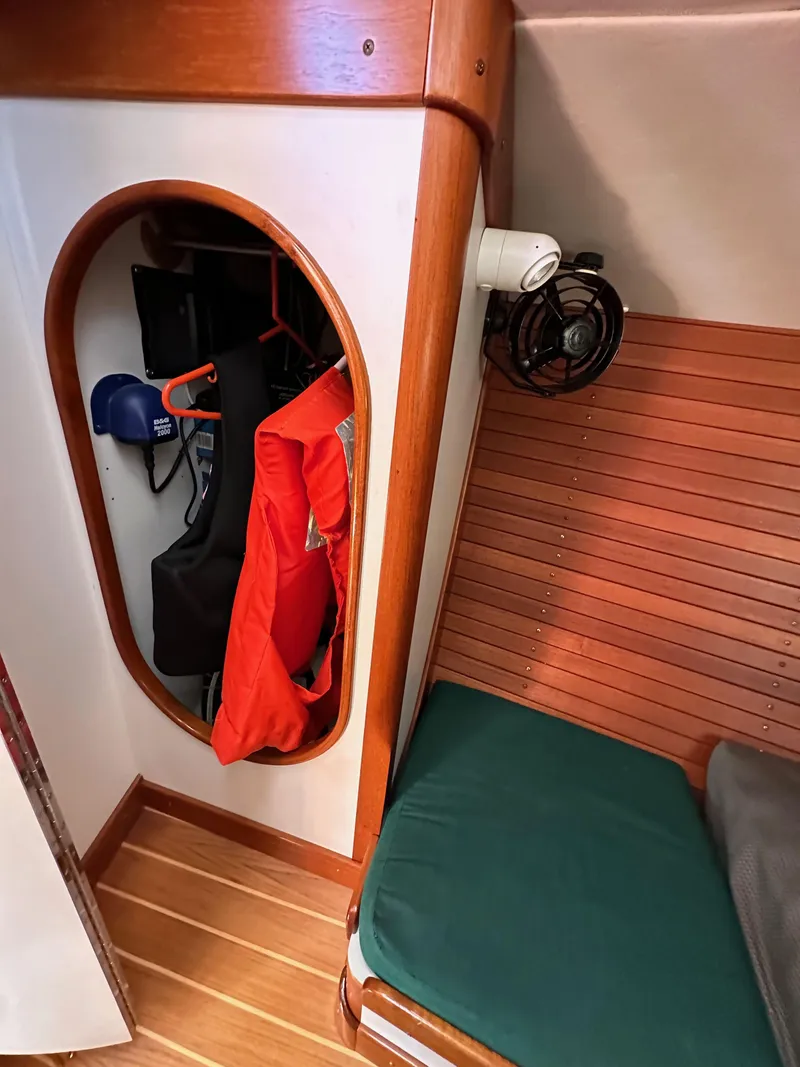 Slide: The Image of Interior of 1996 J Boats J/120 sailboat with wooden accents and storage area. - 48