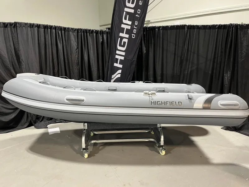 The Image of 2025 Highfield Classic 340 inflatable boat displayed indoors on a stand. - 1