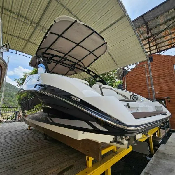 Slide: The Image of 2016 Yamaha Boats 242 Limited S E-Series under a canopy on a wooden dock. - 2