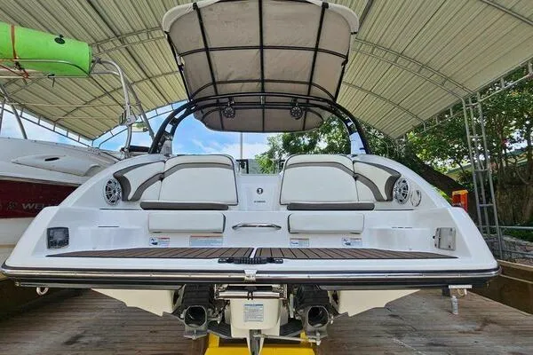 Slide: The Image of 2016 Yamaha Boats 242 Limited S E-Series under canopy, showcasing rear seating and deck. - 6