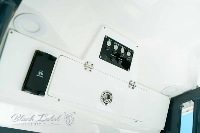 Slide: The Image of 2025 Sea Fox 248 Commander control panel with switches and storage compartment. - 20