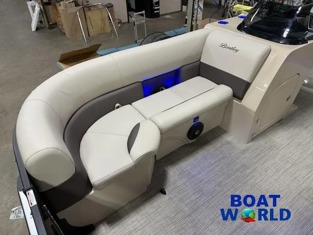 Slide: The Image of 2025 Bentley Pontoons Legacy 223 Swingback Tritoon interior with beige seating and blue LED lighting. - 8