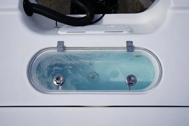 Slide: The Image of Livewell of 2025 Sea Pro 250 Bay boat with clear water and secure latches. - 18
