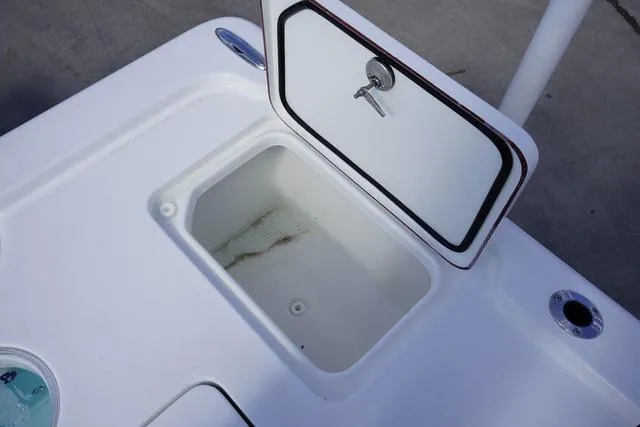 Slide: The Image of 2025 Sea Pro 250 Bay boat storage compartment with open lid and secure lock. - 19