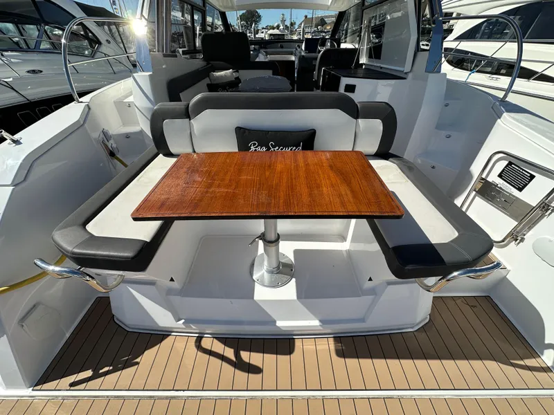 Slide: The Image of 2023 Bavaria SR36 yacht interior with wooden table and cushioned seating. - 16