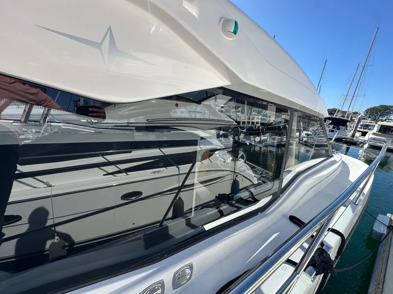 Slide: The Image of 2023 Bavaria SR36 yacht docked at marina, sleek design, reflective windows, sunny day. - 23