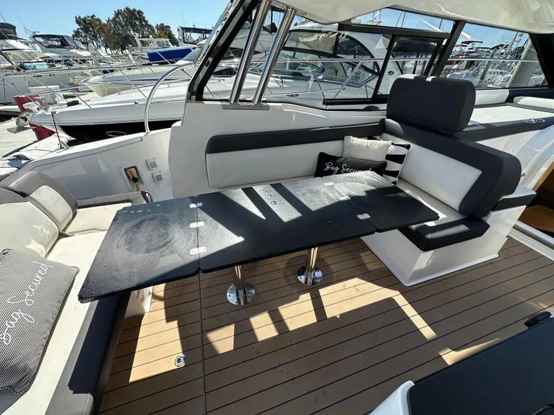 Slide: The Image of 2023 Bavaria SR36 yacht interior with sleek seating and modern design at a marina. - 36