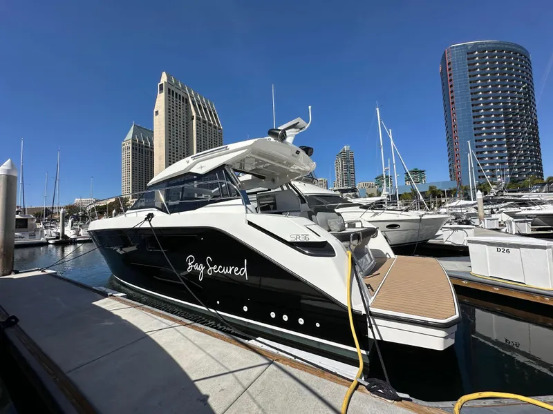 Slide: The Image of 2023 Bavaria SR36 yacht docked in a marina with city skyline background. - 4