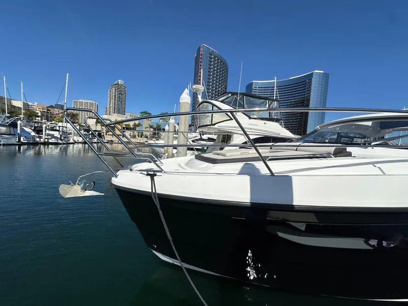 Slide: The Image of 2023 Bavaria SR36 yacht docked in marina with city skyline backdrop. - 6
