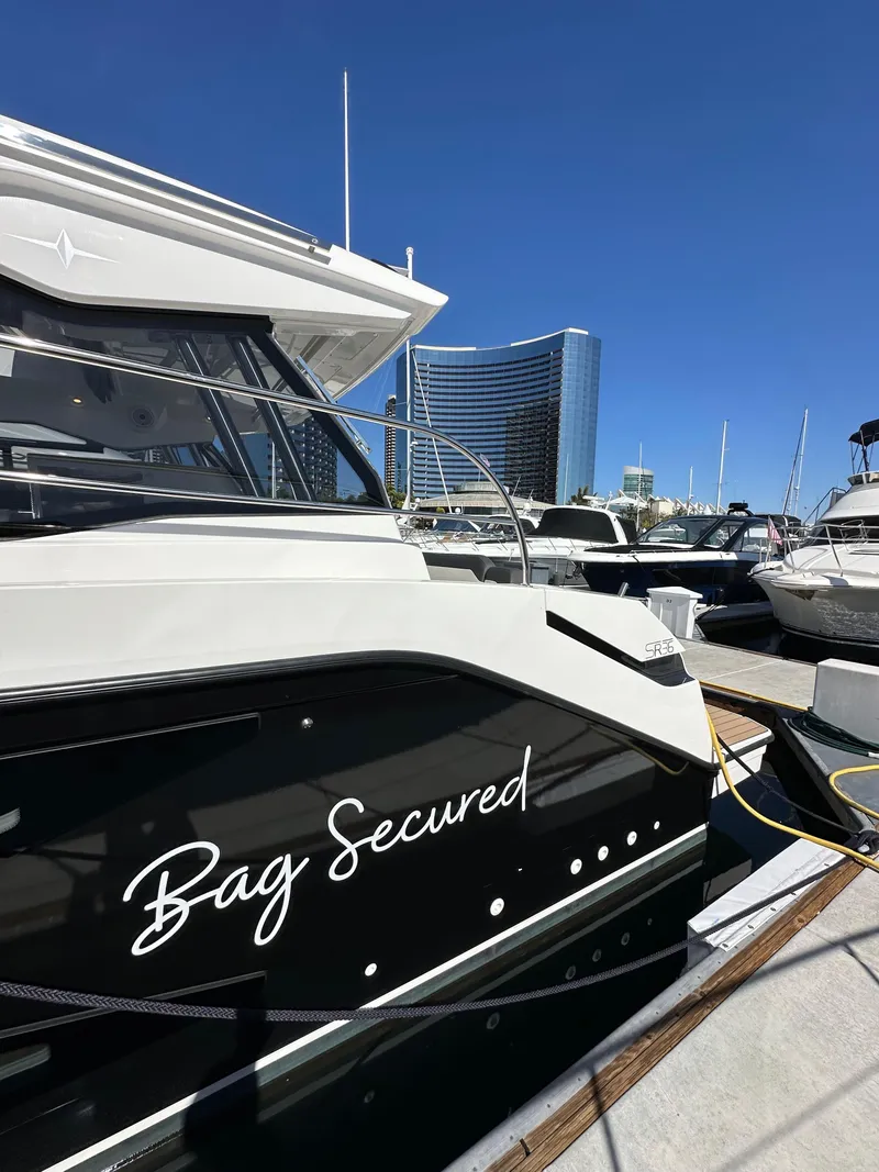 Slide: The Image of 2023 Bavaria SR36 yacht docked, featuring "Bag Secured" text on the side. - 9