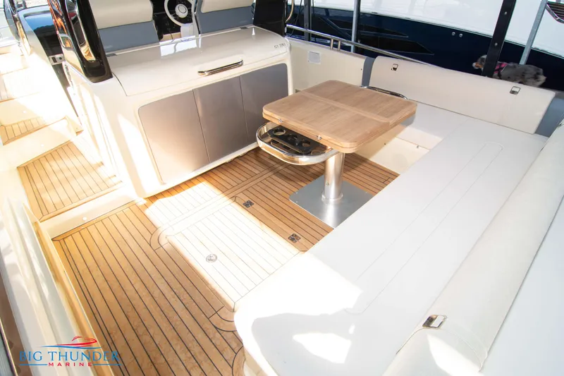 Slide: The Image of 2024 Invictus GT370S yacht interior with wooden flooring and seating area. - 13