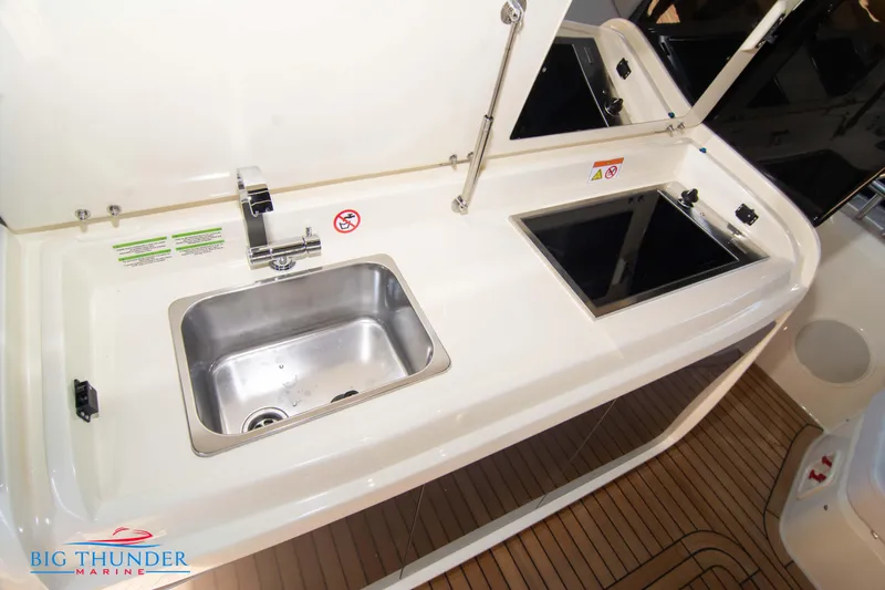 Slide: The Image of 2024 Invictus GT370S yacht kitchenette with sink and stove, featuring modern design. - 18