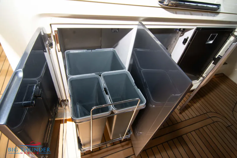 Slide: The Image of 2024 Invictus GT370S yacht interior with organized storage compartments and waste bins. - 22