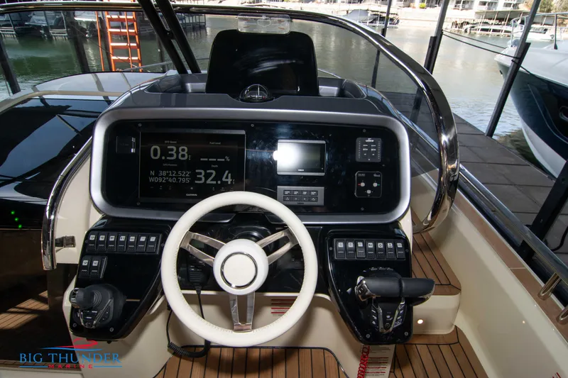 Slide: The Image of 2024 Invictus GT370S boat dashboard with steering wheel and navigation controls. - 28