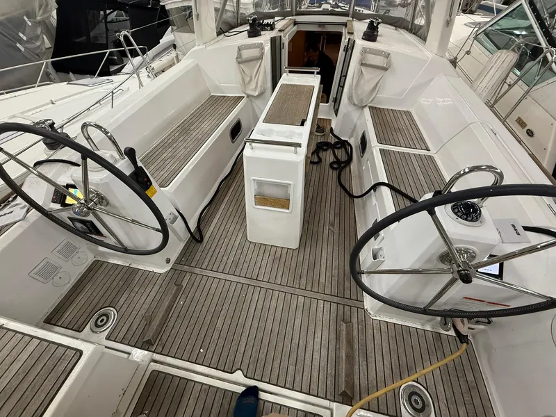 Slide: The Image of 2017 Beneteau Oceanis 38.1 yacht cockpit with dual steering wheels and teak flooring. - 11