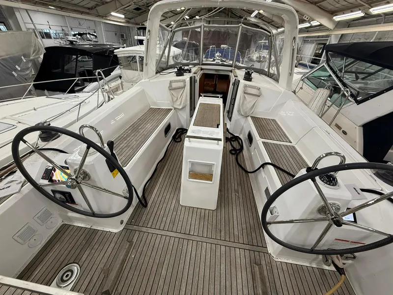 Slide: The Image of 2017 Beneteau Oceanis 38.1 sailboat cockpit with dual steering wheels in a marina setting. - 12
