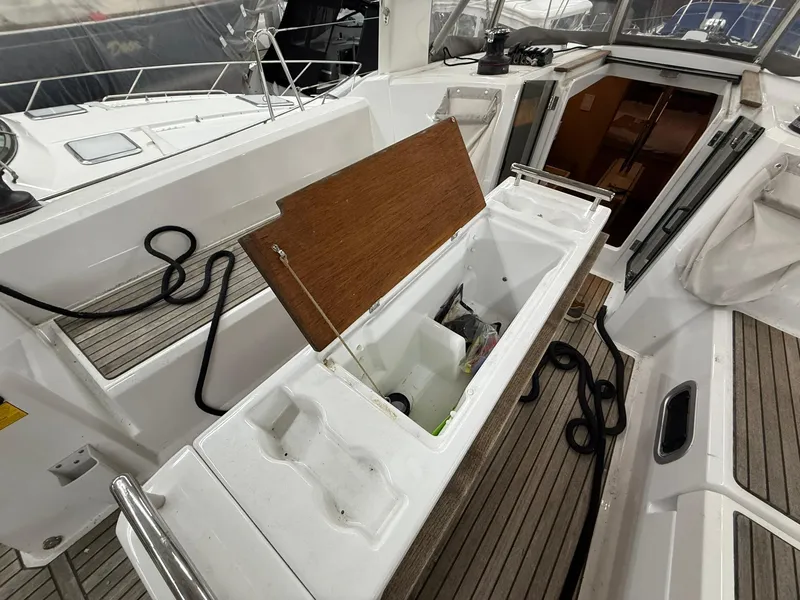 Slide: The Image of 2017 Beneteau Oceanis 38.1 yacht cockpit with open storage compartment and teak flooring. - 18
