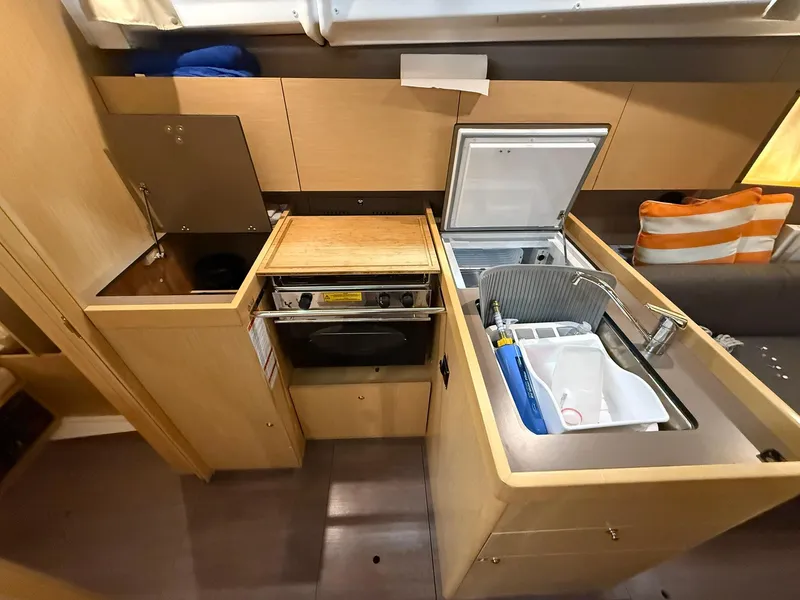 Slide: The Image of 2017 Beneteau Oceanis 38.1 yacht kitchen with sink, stove, and storage cabinets. - 28