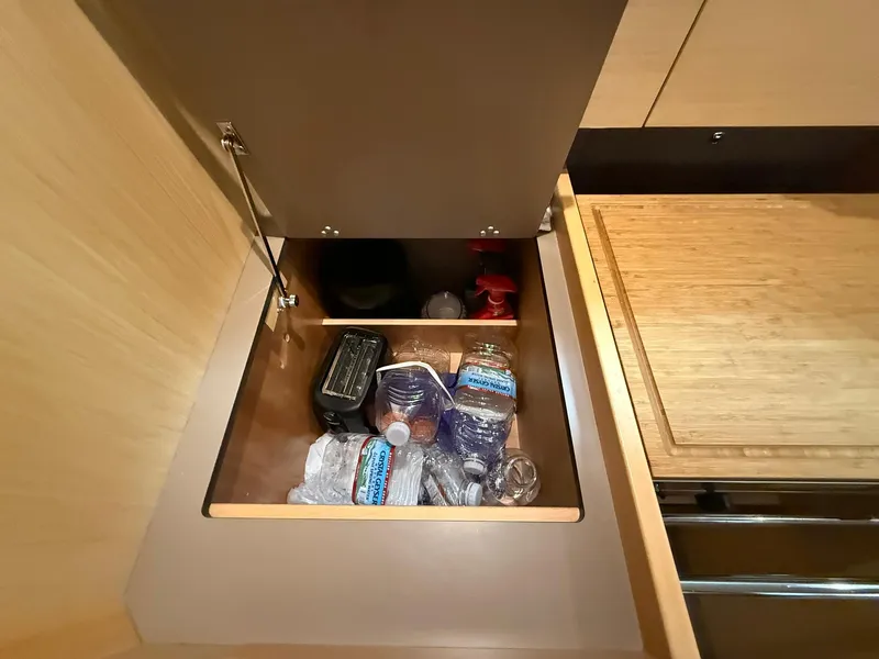 Slide: The Image of Storage compartment in 2017 Beneteau Oceanis 38.1 yacht with water bottles and supplies. - 30