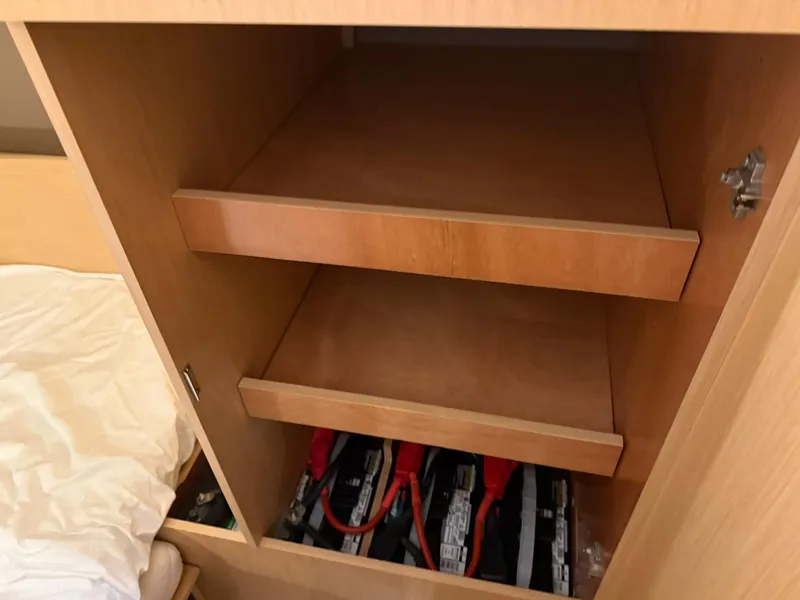 Slide: The Image of Cabinet interior with shelves and batteries in a 2017 Beneteau Oceanis 38.1 sailboat. - 36